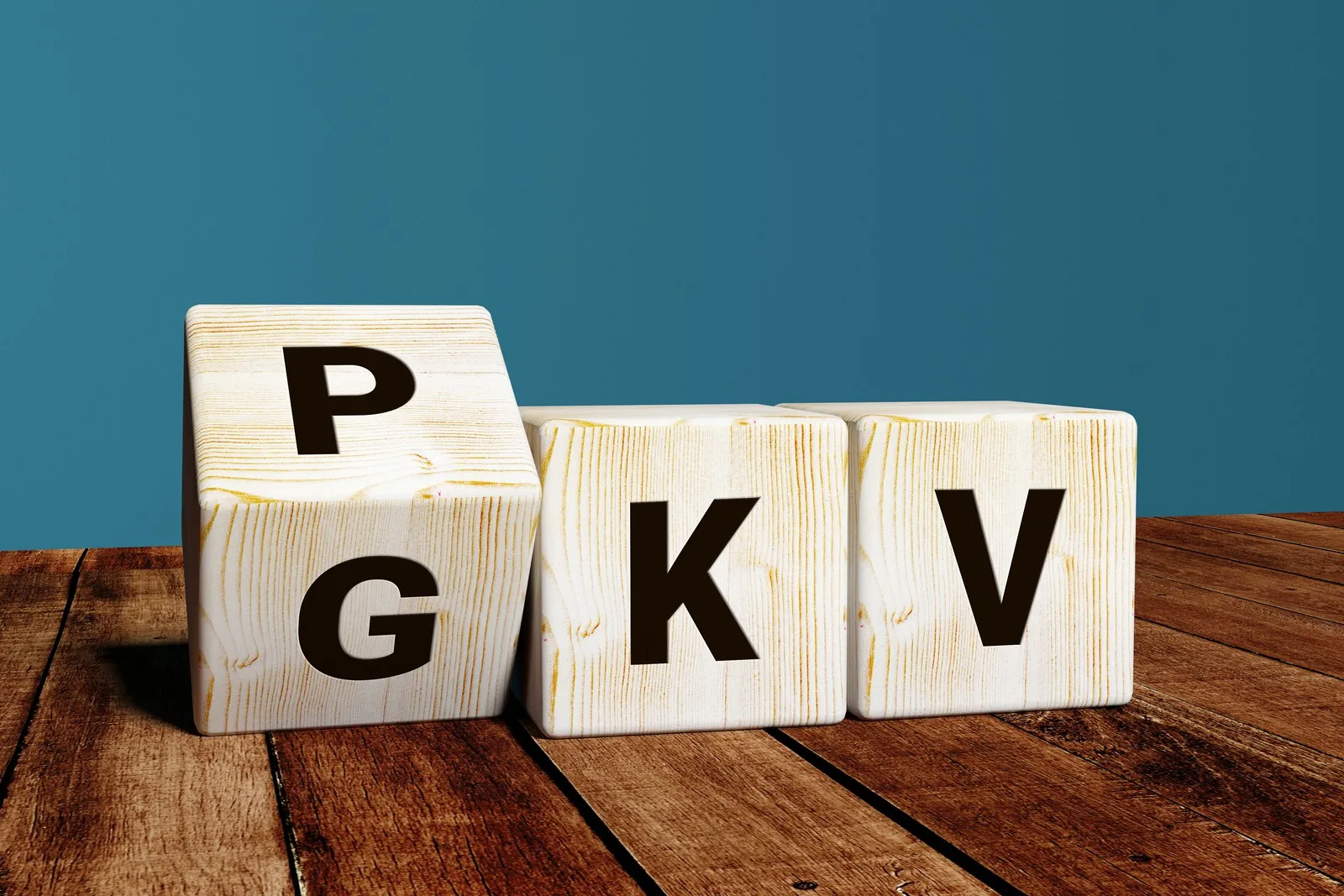 Drei Würfel mit Buchstaben. Der eine Würfel steht auf der Kippe, so kann man auf der einen Würfelseite ein P und auf der anderen ein G erkennen. Dahinter reihen sich die Würfel mit K und V auf. So kann PKV und GKV gelesen werden.